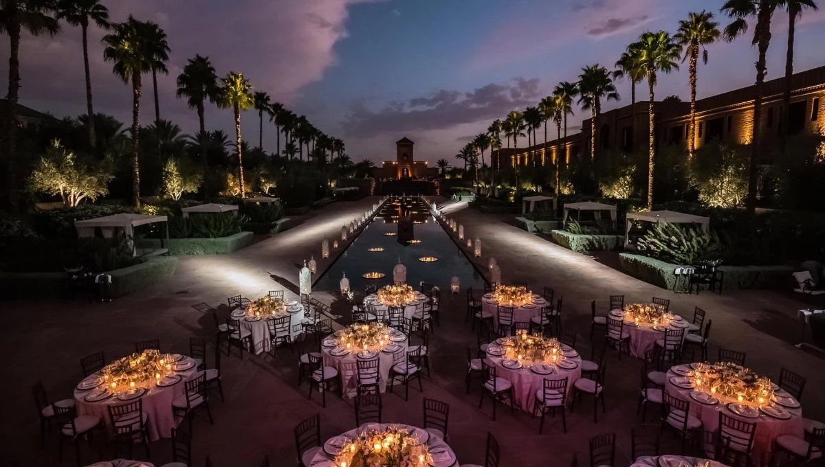 Réception de mariage en soirée au bord d'un long bassin bordé de palmiers, Selman Marrakech
